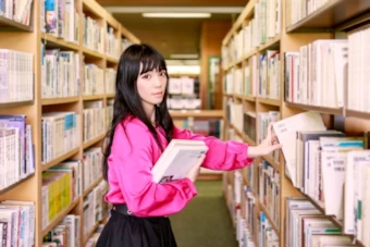 図書館で参考書を取り出す女性