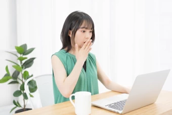 コンピュータを見て驚く女性