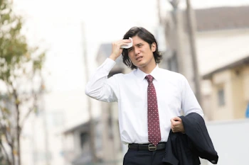 外回りで暑さに耐えるビジネスマン