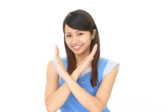 バツ印を示す女性