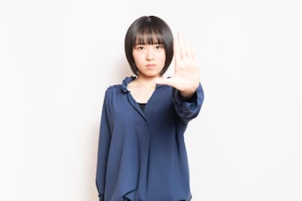 禁止の表示をする女性