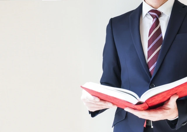 分厚い書籍を読む男性