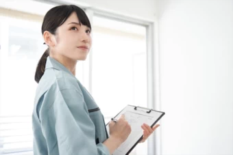 調査をする作業服姿の女性