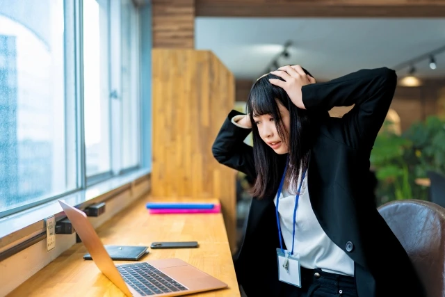 パソコンの前で頭を抱える女性
