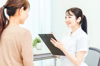 問診の項目を尋ねる女性