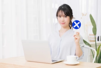 ×マークを示す女性