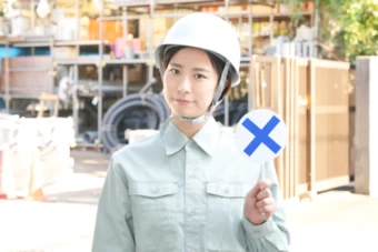 ×マークを示す女性