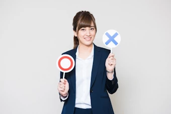 バツ印を掲げる女性