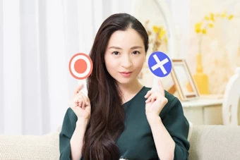 〇と×を示す女性