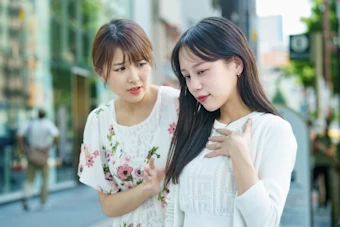 体調不調の仲間を気遣う女性